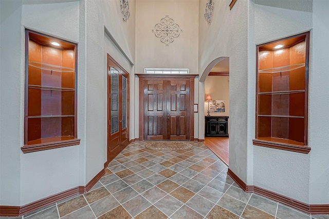 12403 Summer Lake Ranch Dr, Houston, TX 77044 - tiled entrance foyer featuring arched walkways, baseboards, and a high ceiling