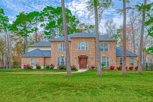 12403 Summer Lake Ranch Dr, Houston, TX 77044 - view of front facade featuring brick siding, a front yard, a shingled roof, and fence