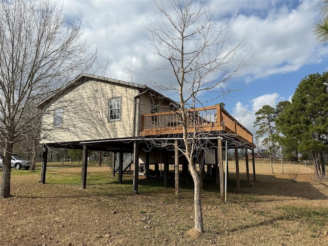 back of property with a lawn and a deck