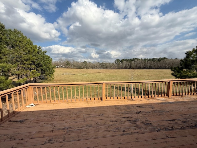 deck with a rural view and a lawn