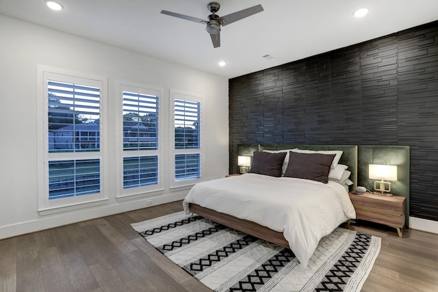 bedroom featuring ceiling fan, wood-type flooring, and multiple windows