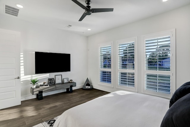 bedroom featuring multiple windows, dark wood-type flooring, and ceiling fan