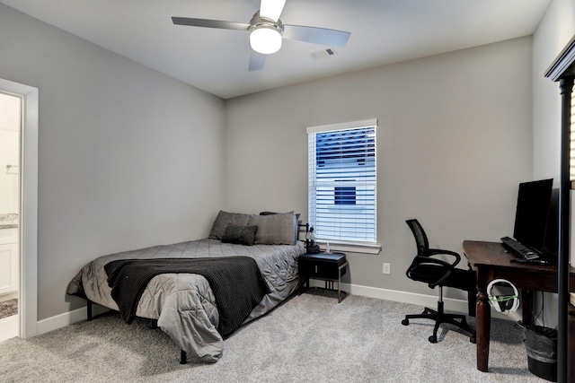 bedroom with light carpet, ensuite bath, and ceiling fan