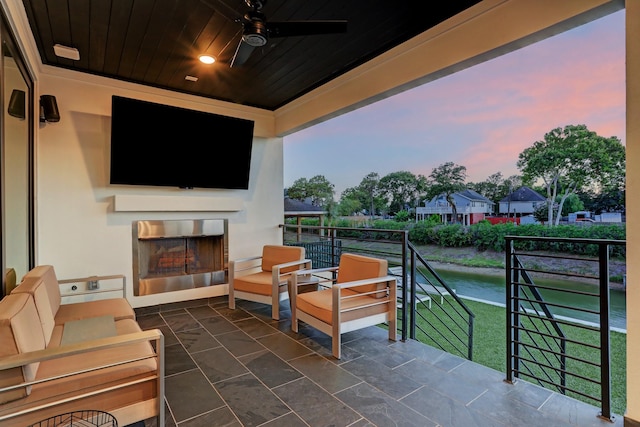 view of patio / terrace featuring ceiling fan and an outdoor fireplace