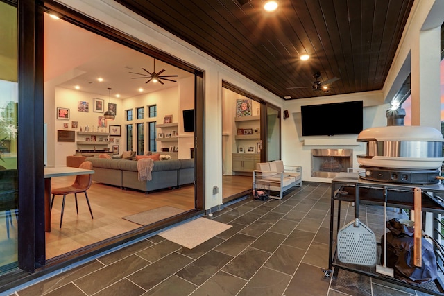 tiled living room with built in features, wooden ceiling, and ceiling fan