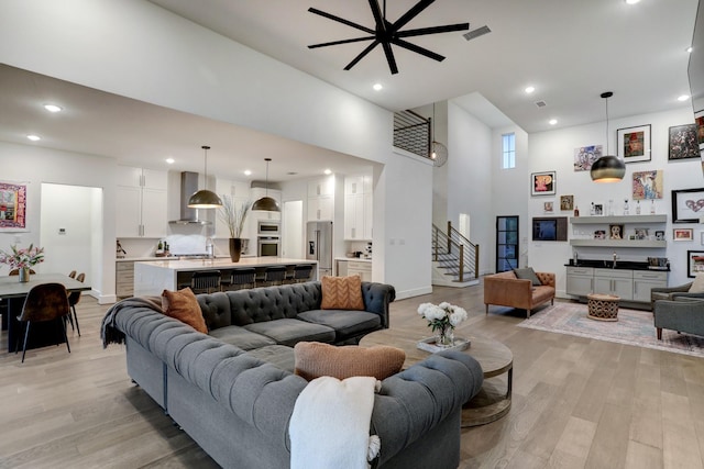 living room featuring light hardwood / wood-style flooring and a high ceiling