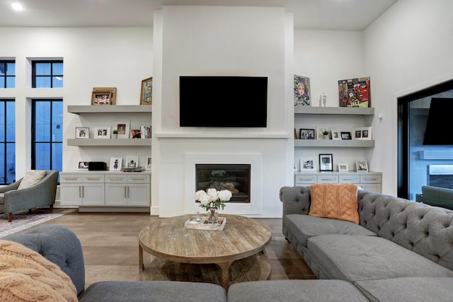 living room with built in features and light hardwood / wood-style floors