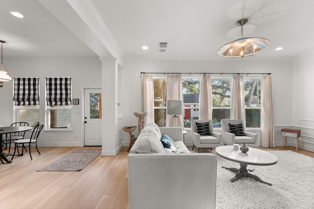 living room featuring ornamental molding and light hardwood / wood-style flooring