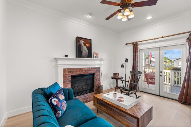 living room with crown molding, a fireplace, french doors, and light hardwood / wood-style flooring