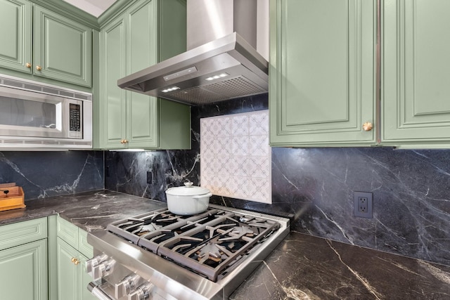 kitchen featuring tasteful backsplash, green cabinets, island range hood, and appliances with stainless steel finishes