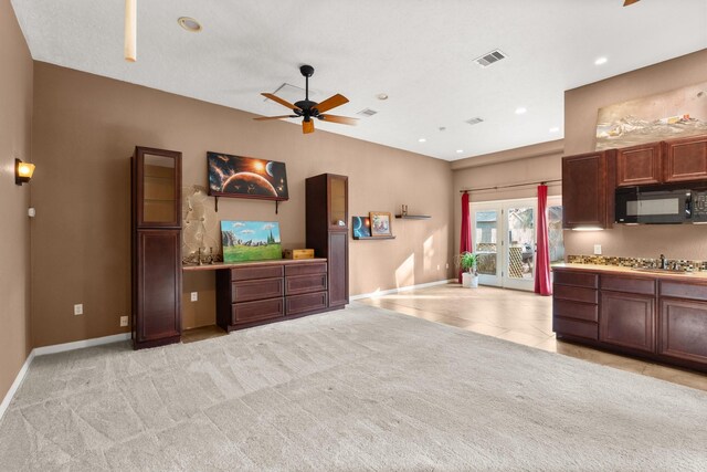 kitchen featuring light carpet, stainless steel gas cooktop, and ceiling fan