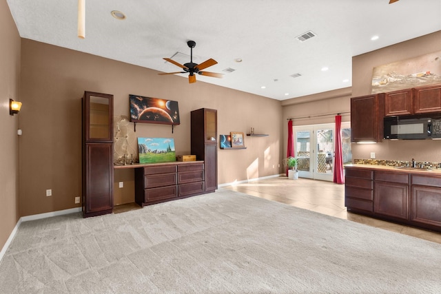 kitchen with stainless steel gas cooktop, light carpet, and ceiling fan