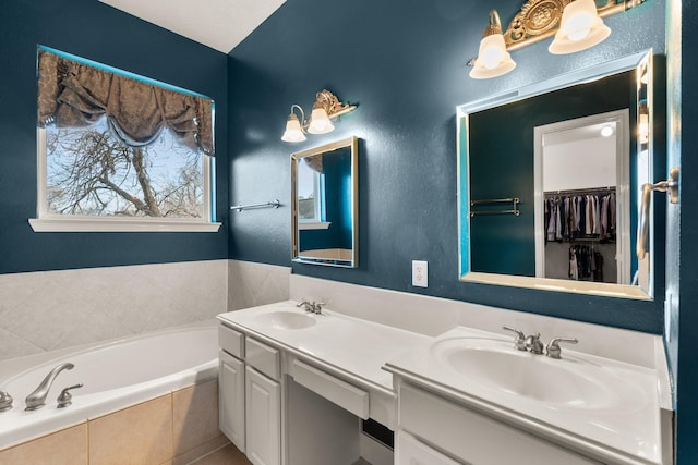 bathroom featuring vanity and tiled tub