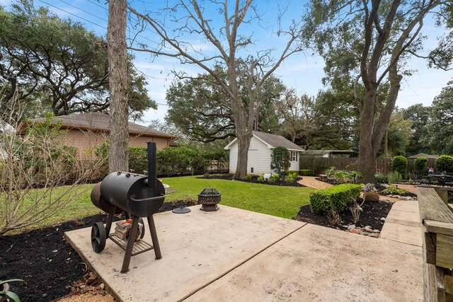 view of patio featuring an outdoor fire pit, area for grilling, and a storage unit