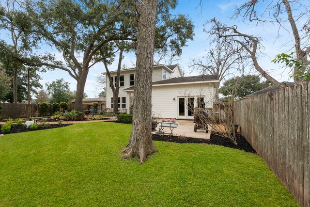 rear view of house with a yard, a patio area, and french doors