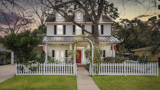 view of front of home with covered porch and a lawn