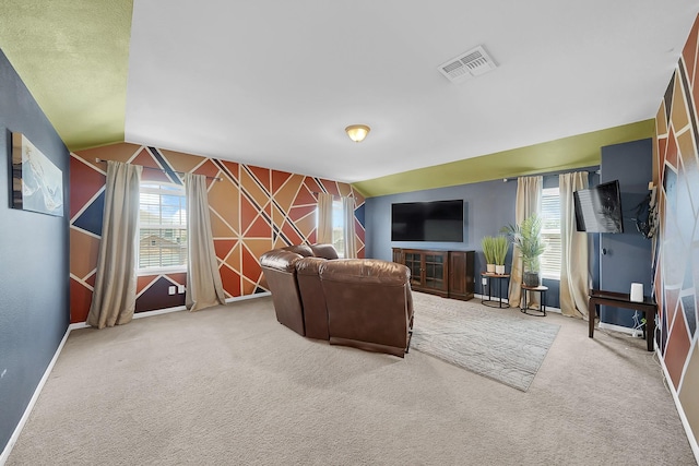 carpeted living room with vaulted ceiling and a wealth of natural light