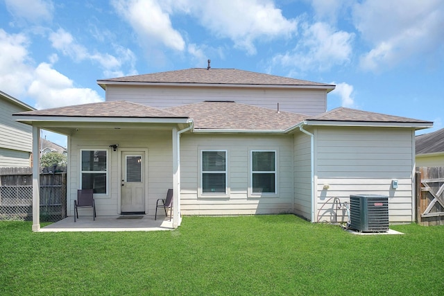 rear view of property featuring a yard, a patio, and central air condition unit