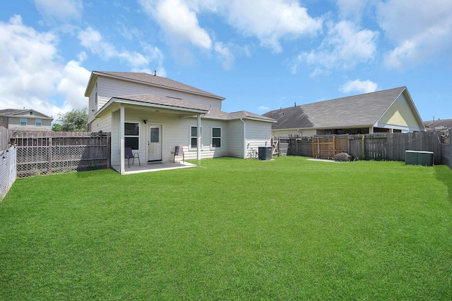 back of property with a yard, central AC unit, and a patio