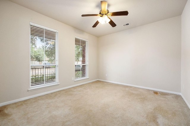 spare room featuring light colored carpet and ceiling fan