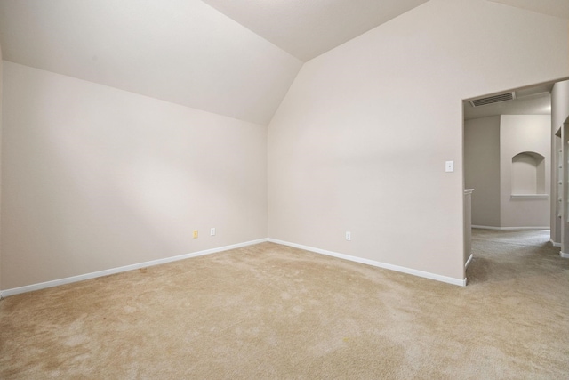 carpeted spare room with lofted ceiling