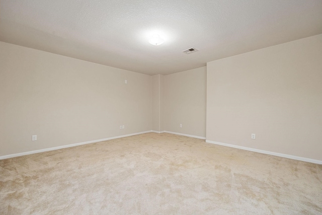 carpeted empty room with a textured ceiling