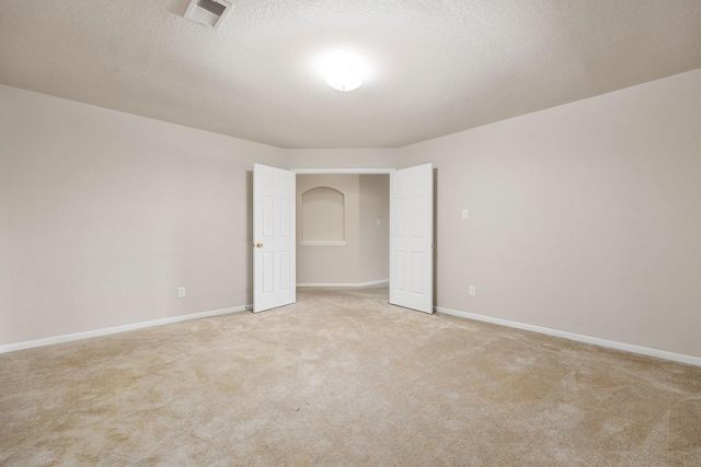 carpeted empty room with a textured ceiling