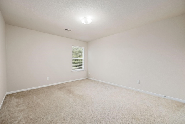 carpeted spare room with a textured ceiling