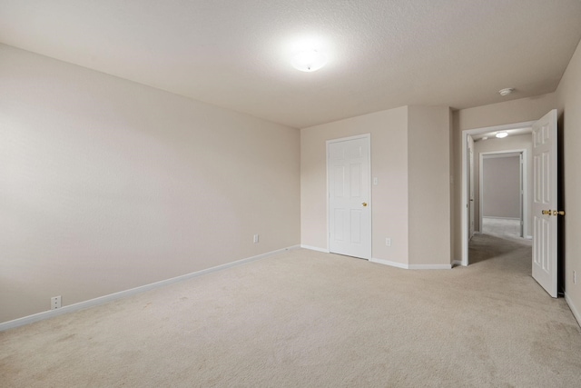 unfurnished bedroom featuring light colored carpet and a textured ceiling