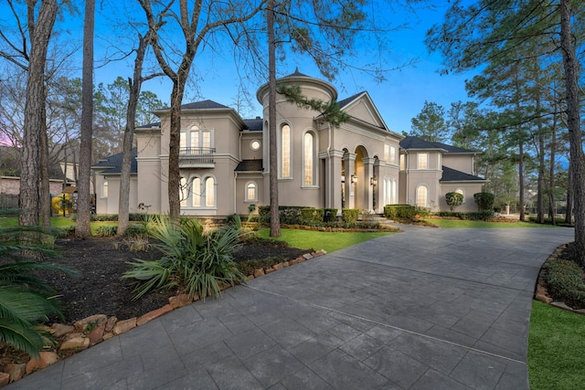 mediterranean / spanish-style house featuring a balcony and a front lawn