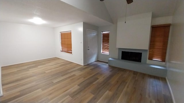 unfurnished living room with lofted ceiling, wood-type flooring, and ceiling fan