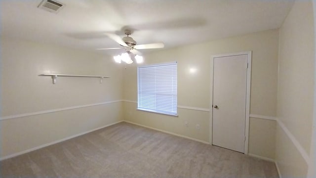 carpeted spare room featuring ceiling fan