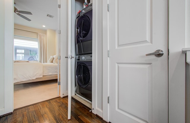 washroom featuring stacked washer / drying machine, dark wood-type flooring, and ceiling fan