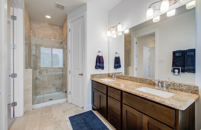 bathroom featuring a shower with door and vanity