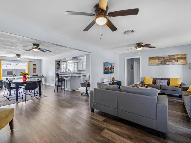 living area featuring dark wood-style floors, baseboards, and visible vents