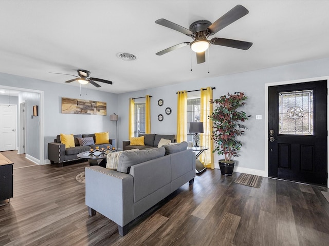 living room with visible vents, baseboards, and wood finished floors