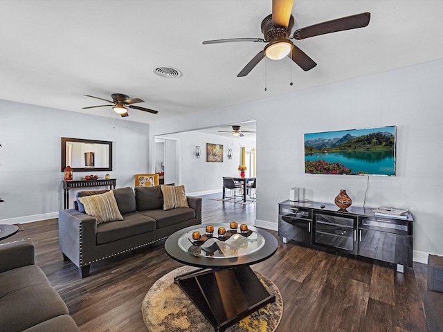 living room featuring baseboards, visible vents, and wood finished floors