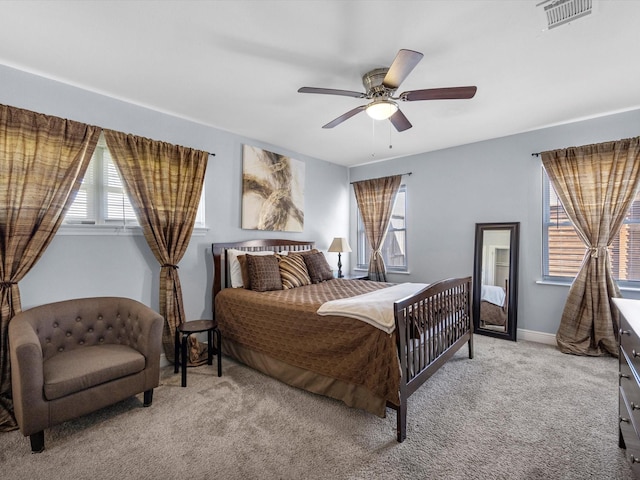 bedroom with light carpet, ceiling fan, visible vents, and baseboards