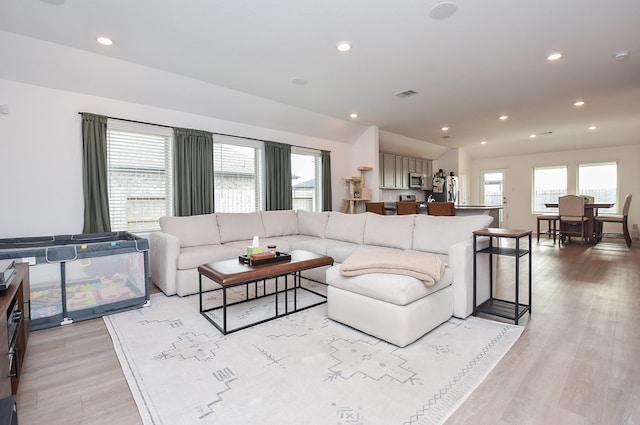 living room featuring vaulted ceiling and light hardwood / wood-style floors