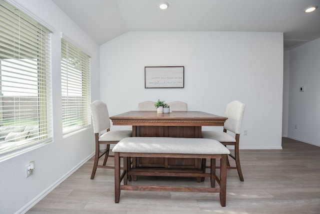 dining room with vaulted ceiling and light wood-type flooring