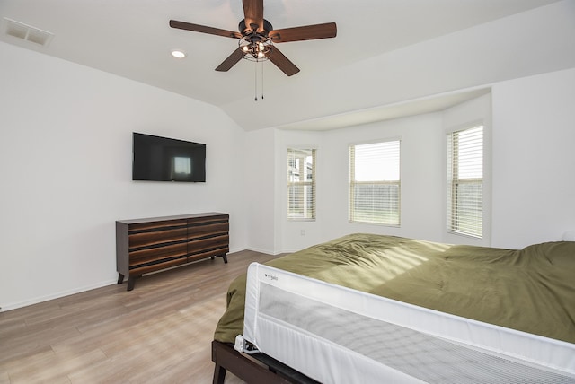 bedroom with vaulted ceiling, ceiling fan, and light wood-type flooring