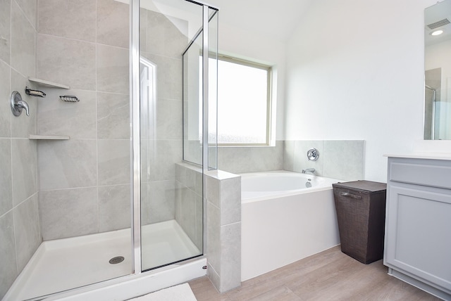 bathroom with vanity, separate shower and tub, and vaulted ceiling