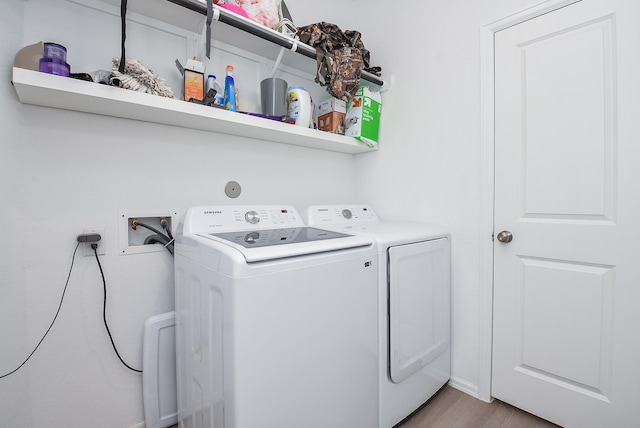 laundry area featuring washing machine and dryer and light wood-type flooring