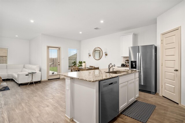 kitchen featuring a kitchen island with sink, sink, white cabinets, and appliances with stainless steel finishes