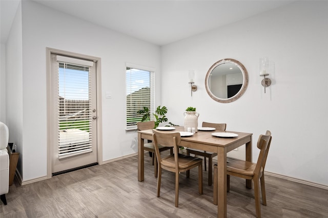 dining space featuring light wood-type flooring and baseboards