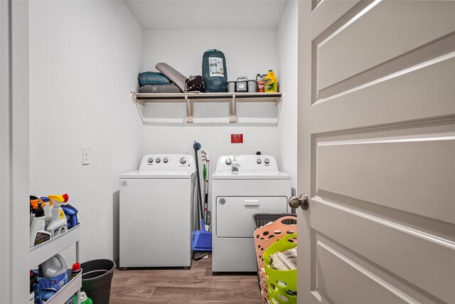 washroom with wood-type flooring and washing machine and dryer