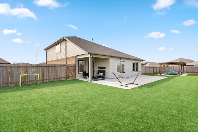 rear view of property with brick siding, a yard, a shingled roof, a patio area, and a fenced backyard