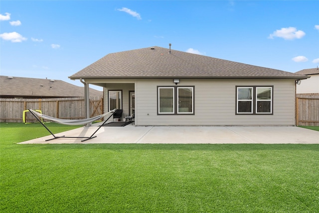 back of house with a shingled roof, a lawn, a patio area, and fence