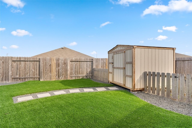 view of yard featuring a storage unit, an outdoor structure, and a fenced backyard