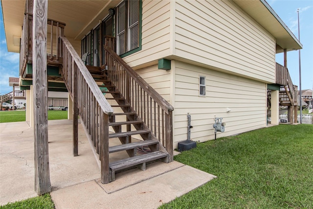 view of side of property with a patio area and a lawn